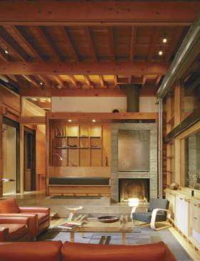 The board-formed concrete on the exposed parts of the foundation is repeated on the fireplace, where individual planks were cast on site and stacked up like logs.