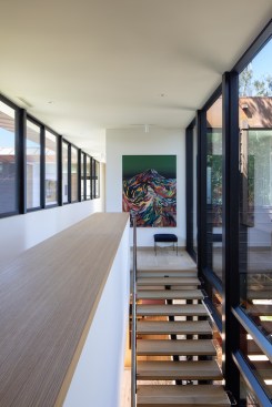 Upstairs, the continuous ribbon of sliding windows (left) overlooks the central pool courtyard, while the expansive double height glazing (right) provides an intimate spatial relationship to the oaks in the atrium garden.