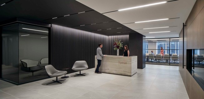 The separation of executive areas from collaborative common areas is visually represented by the division of light and dark woods. 