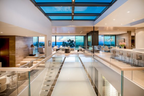 Modern Beverly Hills home with skylight over glass bridge in an open plan space.