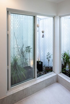 The imaginative shower is placed in the corner of the master bath with full length windows for the outside shower feel.