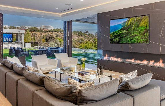 Indoor outdoor living room at luxury resort style modern California home.