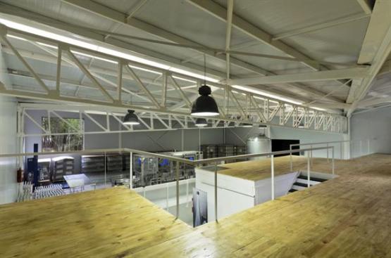 A lofted space above the offices provides casual meeting space overlooking the bottling process portion of the facility.