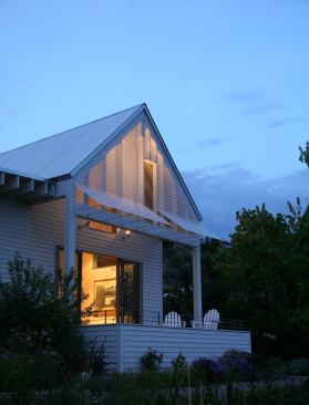When lit from below at night, the Lexan sunshades on the south porch help the south gable become an outside lantern.