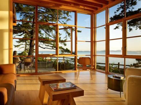 Floor to ceiling wood windows maximize water views from the living room. 