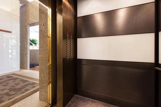 LEVELe-104 Elevator Interior with main panels in ViviChrome Chromis glass, White interlayer, Opalex finish; upper accent and handrail panels in Fused Nickel Silver, Sandstone finish; lower accent panels in Fused Nickel Silver, Sandstone finish, Dallas Impression pattern at 1000 Broadway, Portland, Oregon