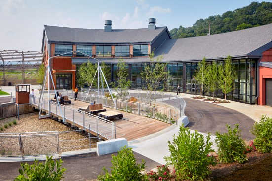 The site design integrates the roundhouse and its industrial relics into a rehabilitated brownfield along the Monongahela River.