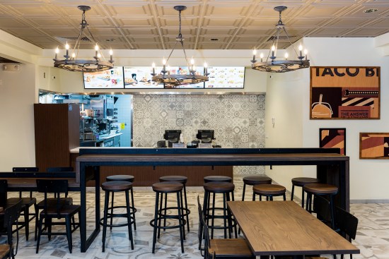 Taco Bell’s new Heritage design has warm white walls, heavy timbers, and coffered ceilings made with Ceilume’s Stratford panels.