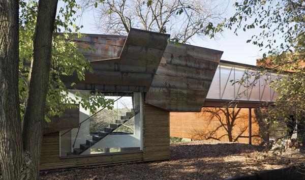 At the entryway, a perforated-metal staircase preserves openness and light.