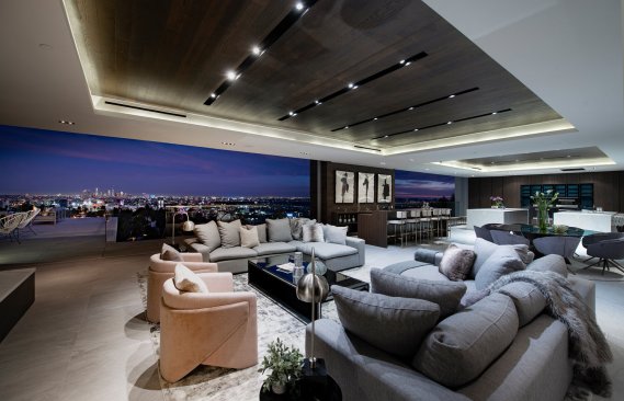 Luxury Hollywood Hills home living room with recessed lighting and sliding glass walls.