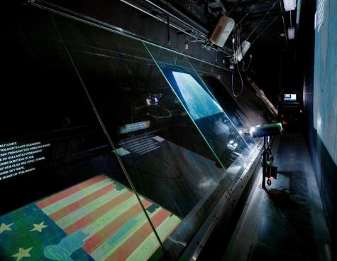 Given the historical significance of this object, all equipment and devices are external to the display environment. A light attic separated from the display case allows for illumination with good color rendering. The Star-Spangled Banner is lit using a single projector that carefully displays a calibrated image that function as a light reduction screen on the display table. This method of visible light control is capable of maintaining a uniformity of 1 footcandle with +/- 0.25 footcandle variation from this lighting baseline.