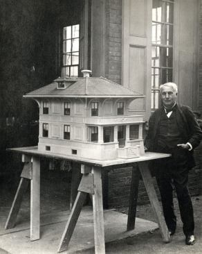 Thomas Edison poses with a model of one of his more obscure and less successful inventions, a poured-concrete house of 1906-08. Contractors required some $175,000 in equipment, including nickel-plated iron forms, to fabricate the houses. Fewer than 100 were built.