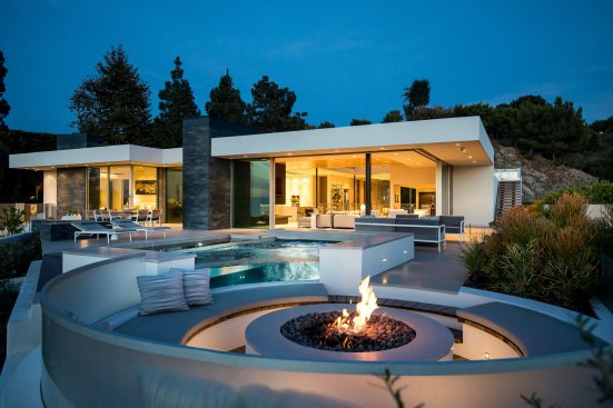 Beverly Hills home viewed from the sunken seating around the poolside fire pit.