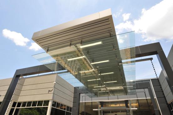 The Novelis Global Research & Technology Center?s public entrance, formerly pedimented precast concrete and glass, now features a 38-foot-long cantilevered aluminum-clad steel and glass canopy.