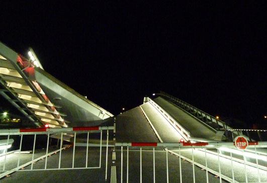 The deck is still washed in white light as the bridge begins to open.