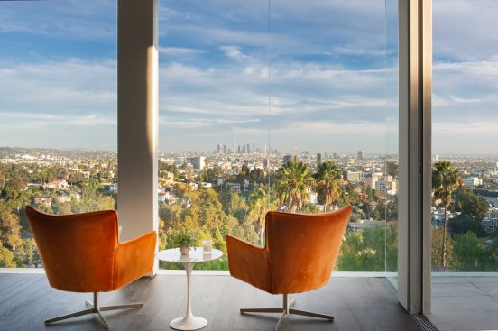 Modern design living room at Hollywood Hills home with sliding glass wall views.