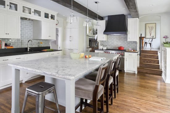 Large white kitchen with gray accents and beamed ceiling