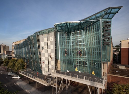 Exterior wall anchored to the facade of a parking garage and former movie theater.