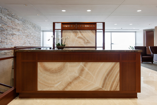 Reception desk and partition in ViviStone Cream Onyx glass with Pearlex finish at Burr & Forman, Orlando, Florida
