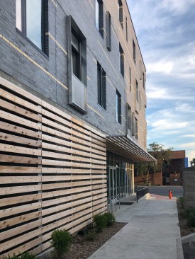 Though constructed of dark manganese ironspot brick, corner windows and a pattern of discontinuous light brick dashes wrapping the entire building lighten the brick mass visually over the more transparent ground level. Cedar screen walls and soffits add warmth to the lower level enhancing the pedestrian experience.