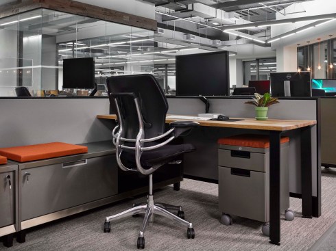 The workstations, by Teknion, were customized with solid wood desktops and raw steel—a first for the manufacturer. The mix of materials was inspired by the neighborhood’s industrial history. Accent colors were specified for seating cushions that reflect the company brand.