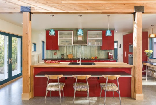 Straight on view of kitchen with shiny red cabinets in north woods cabin