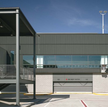The exterior of the arrival gates is clad in a system of concealed-fastener corrugated wall panels in a gunmetal color. Access stairs and baggage handling areas offer necessary access for airline employees.
