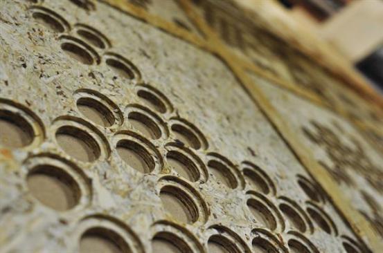 Oriented strand board was milled on a three-axis CNC router to correspond to the positive and negative bumps on each specific tile. These boards were fitted behind the tiles and attached with adhesive to give support to the thin polystyrene material and to ensure that the tiles were spaced uniformly.