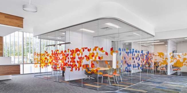 Office cluster with curved glass corners and super graphics. 