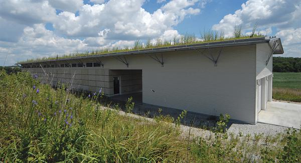 Clad in limestone panels and corrugated metal, the house hugs the contours of the landscape.