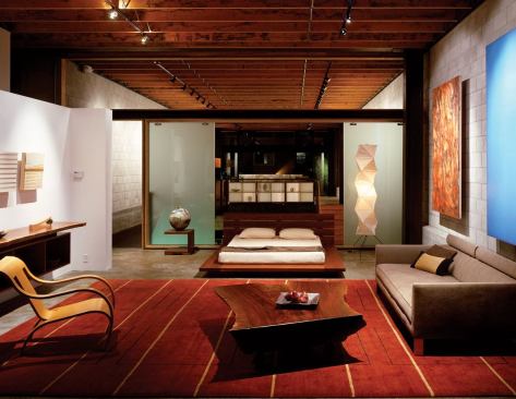 Across the long bridge is Sagan’s living/sleeping studio, where a bath and closet are tucked behind the white wall.