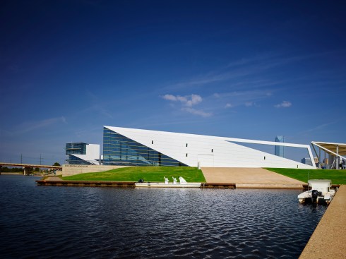 The east elevation is parallel to a river inlet allowing rowing shells to access the river via a concrete ramp.  The inlet size allows for a 60’ long boat to maneuver.  The open beam frames Downtown.  The gold “notes” are rhythmically placed on the façade. 