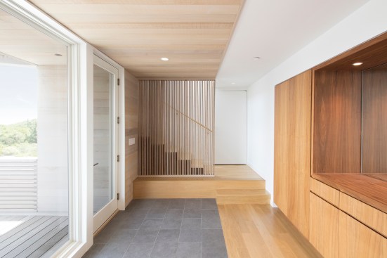 Foyer with built-in cabinetry and stair to main living level above