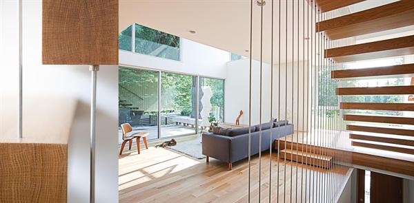 A tension rod supported stair gives the effect of cantilevered treads, while also meeting code. 