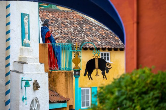 Through the archway of the Bridge House toward a statue of Saint Peter and a black sheep cutout.