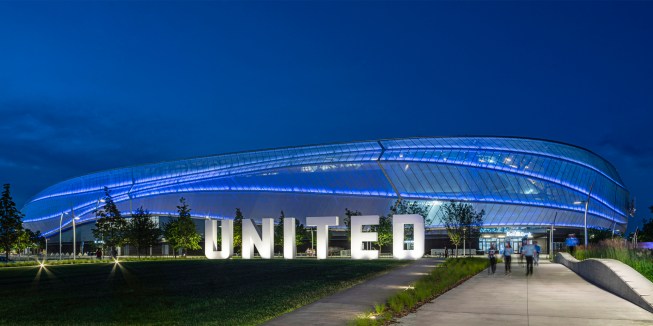 In-grade uplights with a wide wall wash distribution illuminate the UNITED sculpture, a part of the overall façade composition.