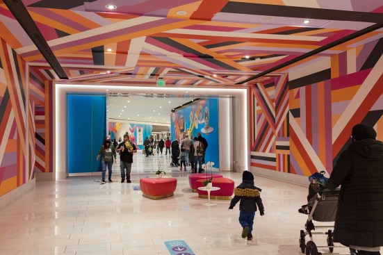 Red ottomans and other colorful design elements help break up the complex's otherwise white expanses.