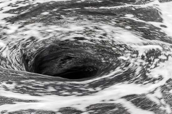 A closeup of circling body of black water.