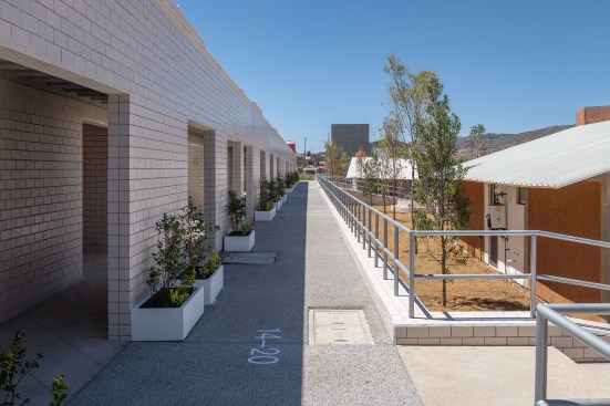 Walkway separating the welcome and education center designed by MOS (at left), from the house prototypes (at right).