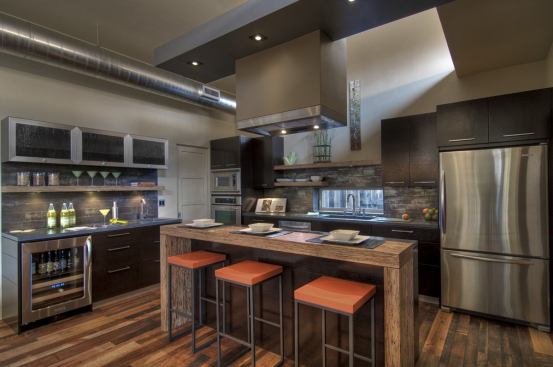 The modern kitchen features Pioneer Millworks reclaimed flooring, Energy Star-rated refrigerator and dishwasher from KitchenAid, locally sourced wood cabinets, and Squak Mountain recycled-content countertops. Clerestory windows flood the open room with natural light.