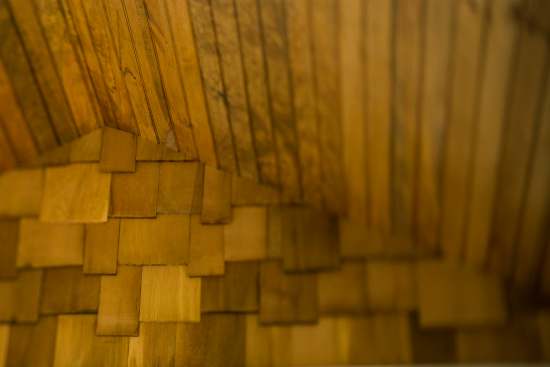 The interior's rustic wood ceiling and shingles provide visual warmth and texture to the space.