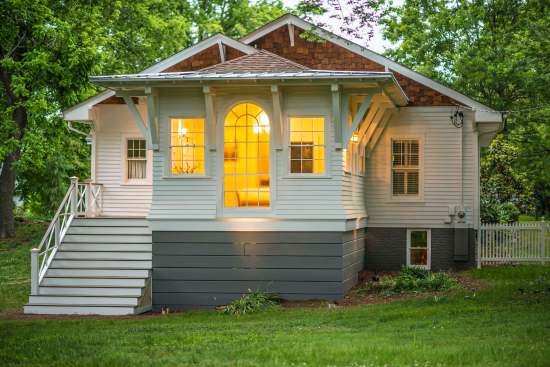 The studio addition nicely fits the scale of the existing house, and the grey of the boards at the base visually ties in with the existing house. The slight kick-out of the siding provides a playful transition.