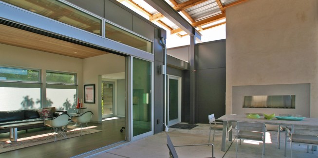 A nearly seamless transition from indoor to outdoor living spaces featuring the stainless steel J Series outdoor fireplace by European Home.