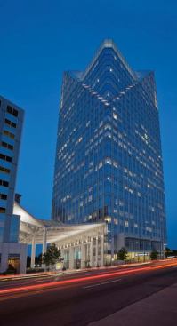 The entrance, with its welcoming bright awning, enlivens the streetscape and guides visitors to the off-street entrance. Its triangular form alludes to the top of the building. At night, the architect's intention was for the building to read as a coherent form and not a disembodied illuminated crown.