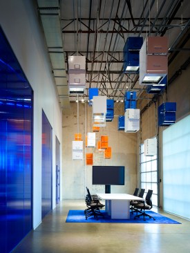 The original delivery dock is transformed into a primary conference and presentation space.  A “cloud” made of pre-owned filing cabinets suspended from the ceiling represent the transition from paper-based systems to storing information digitally in the cloud.  