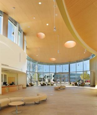 The main reception space serves as a bridge between the campus and San Rafael, the seat of Marin County. Entrances are set into glass walls on either end of the space. Clerestory windows and porthole skylights-in a ceiling clad with Ceilings Plus metal perforated tiles in a wood finish-introduce even more daylight.