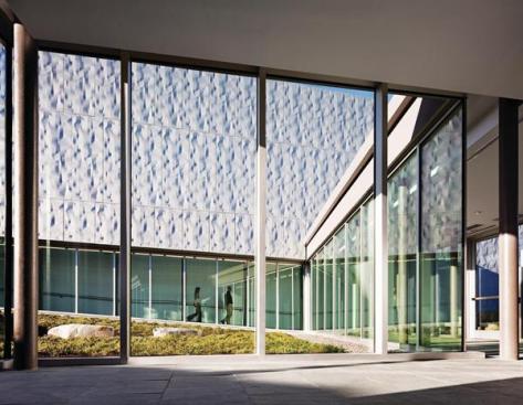A continuous run of uncovered vision glass?the only one in the facility?clads the corridors that face onto the central courtyard. Hidden from public view by a berm, the west end of the courtyard is capped by an enclosed walkway so that personnel can securely travel between the buildings.