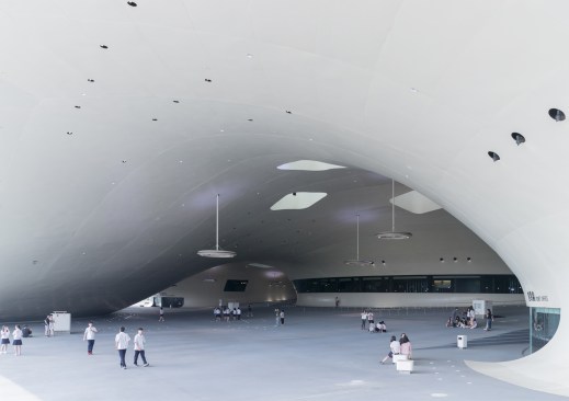 The Banyan Plaza, a partially enclosed public space where the cooling wind can freely flow. Between the four formal performance halls, which form the ‘trunks’ that support the undulating roof, a topography rising from ground level to plus five metres becomes part of the park’s landscape.
