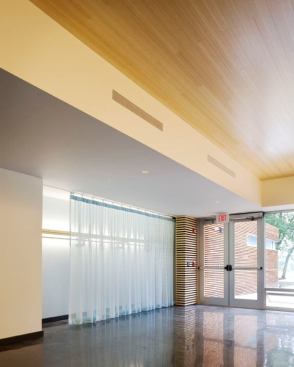 Linear fluorescent coves render the sheer curtain of the coat closet luminous when closed. 