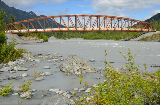 The+glulam-timber+bridge+emulates+the+railroad+work+camp+culture+of+the+early+20th+century%2c+and+its+overall+structure+complements+the+style+of+an+existing+steel+railroad+bridge+a+quarter+mile+downriver.+